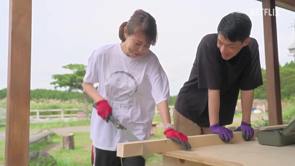 シーズン3の公式予告で2人の住民が木材を切るDIY作業をする場面
