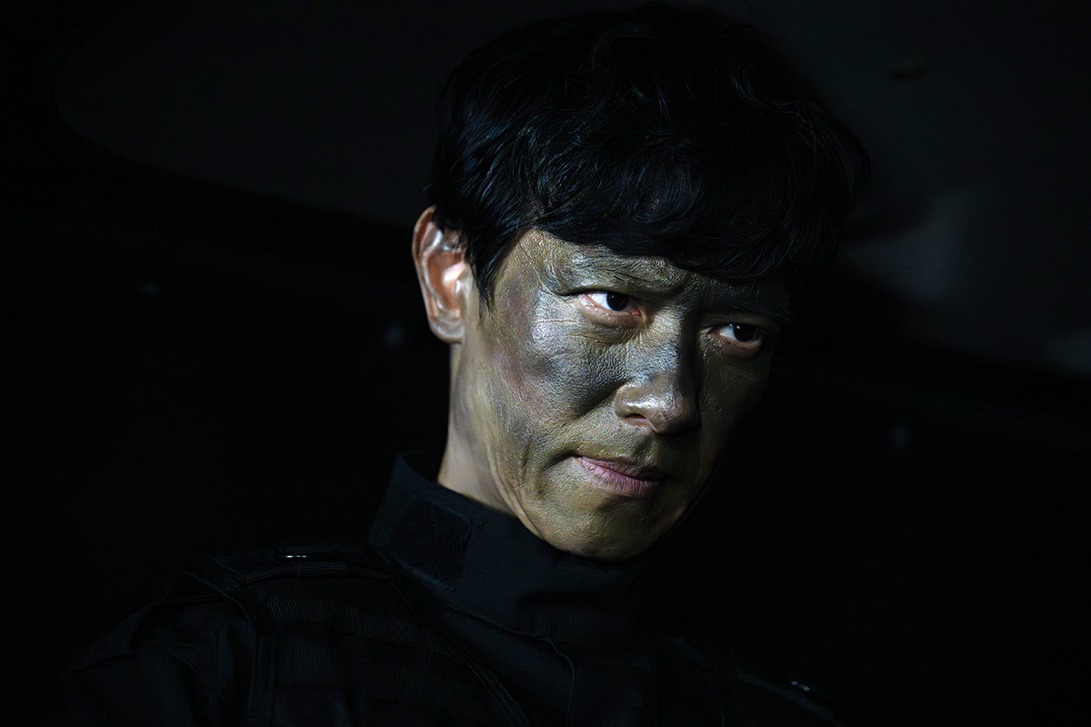 VIVANT第19話公式場面写真、迷彩を施した乃木の表情